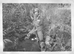 "Boyd Shaner cleaning his rifle in bivouac. It is just in front of our tent, but you can't see it."
